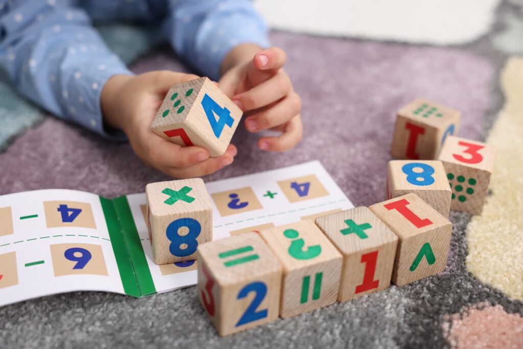 Child learning basic math with colorful wooden numbers