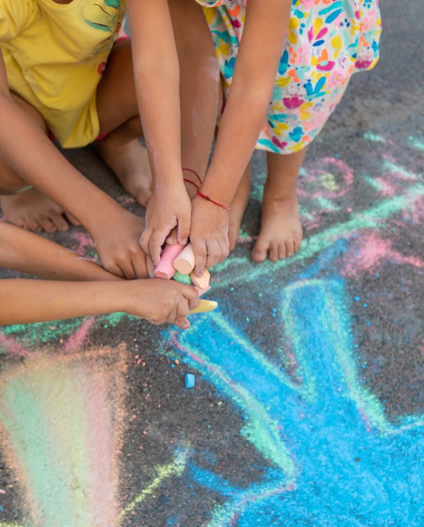 Children drawing with chalk on the sidewalk