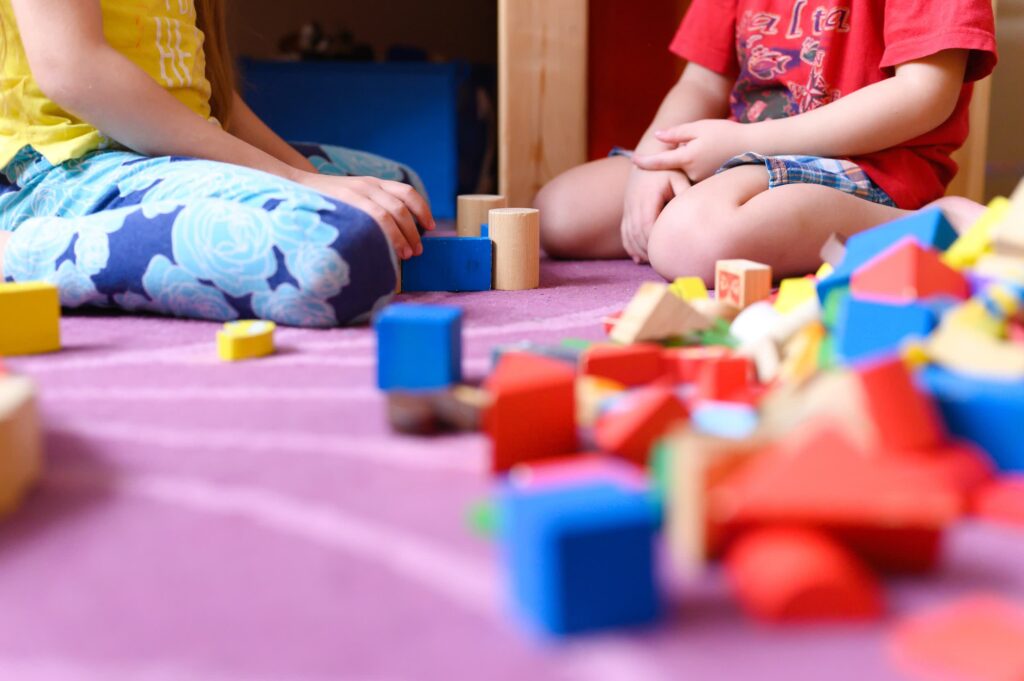 Children playing with colorful wooden blocks indoors