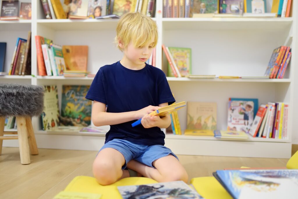 Focused boy reading in a sunny library